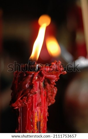 A red candle is lit in a Buddhist monastery
