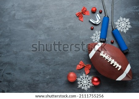 Rugby ball, jumping rope and Christmas decor on dark background