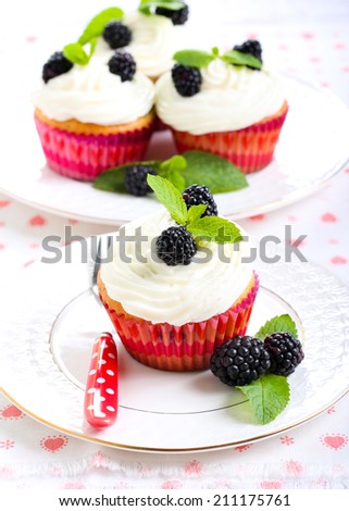 Cupcakes with blackberry over cream