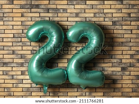 Number 22 made of balloons on brick background
