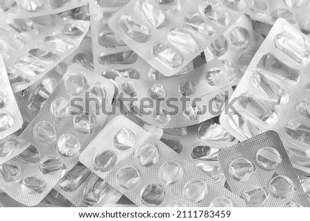 Pile of empty pill blisters. Treatment concept. Many blank blisters from pills as a background. Shallow depth of field. Selective focus. Royalty-Free Stock Photo #2111783459