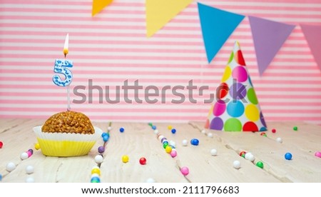 Happy birthday for 5 years old. Festive background with muffin. Copy the birthday card for a five year old on a pink background