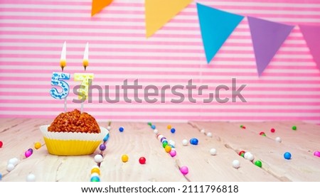 Happy birthday to 57 years old. Festive background with muffin. Copy space birthday card for fifty seven years old on a pink background.