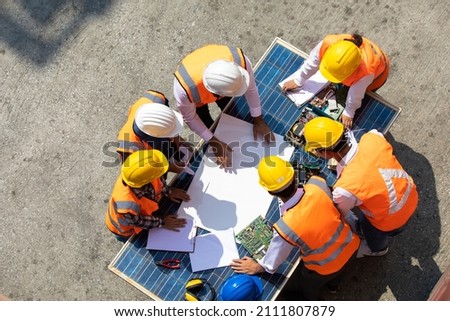 Ethnic diversity worker people, Success teamwork. Group of professional engineering people wearing hardhat safety helmet meeting with solar photovoltaic panels discussion in new project