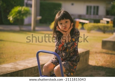 Life during covid-19 pandemic. Portrait of modern child in blue overall with medical mask on the playground outdoors in the city.