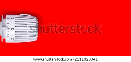 Thermostatic radiator valve on red background. Panoamic image wih copy space.