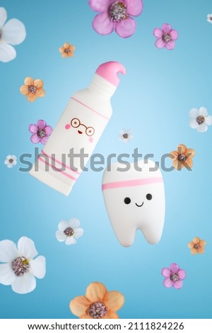 Funny toothpaste and tooth with flowers on a blue background. Dental concept. Stomatology. Summer spring postcard. Selective focus