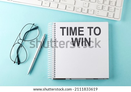 Keyboard, notebook,pen and glasses on blue background , text TIME TO WIN