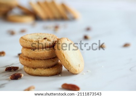 Stack of pecan sandies cookies. Selective focus with blurred foreground and background. Royalty-Free Stock Photo #2111873543