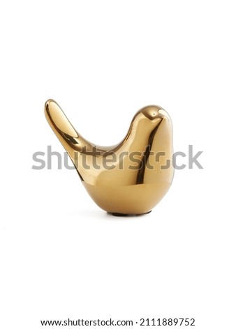 Detail shot of a figurine of a golden shiny bird with a raised tail. The porcelain statuette is isolated on the white background.