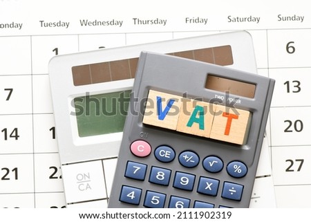 VAT word arranged with wooden letters on the calculator screen. Settlement VAT in Poland.