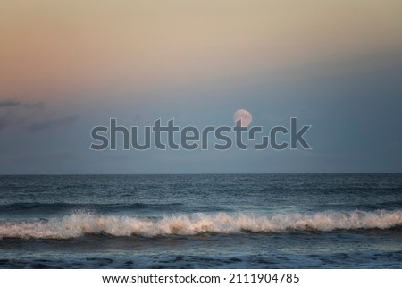 Seascape with moon at sunset
