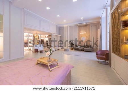 spacious expensive luxury bright interior of open-plan apartment in pink colors with dressing room, bedroom area and cozy area for guests with soft furniture. fashionable LED lighting and huge windows