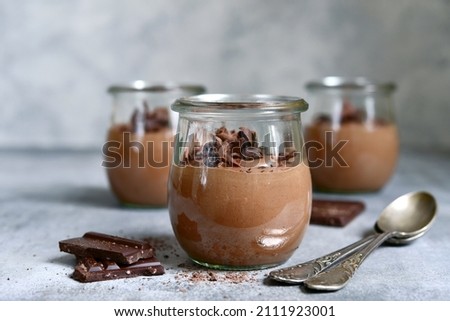 Delicious chocolate mousse in a vintage glasse jar on a light grey slate, stone or concrete background. Royalty-Free Stock Photo #2111923001