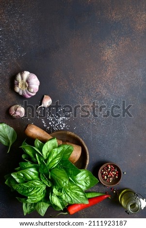 Traditional mediterranean spices : sea salt, basil, garlic, pepper on a dark slate, stone or concrete background. Top view with copy space.