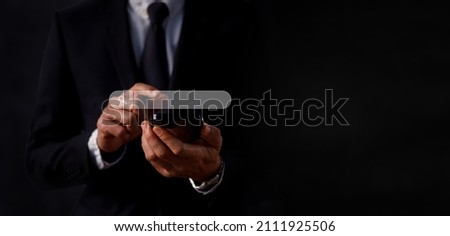 Close up of Businessman touching on smart mobile phone for input wording and searching from a web browser. Technology with copy space concept. Royalty-Free Stock Photo #2111925506