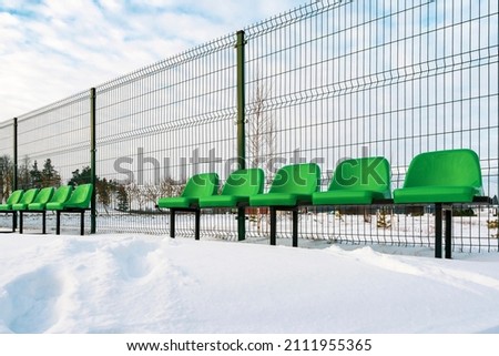 The row of empty plastic green seats at sports stadium