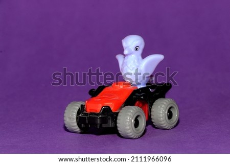 baby owl drives his red car on a purple background