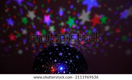 kids projector reflects moving colorful stars on the wall creating psychedelic night sky effect - colorful night background with stars in the sky - disco light 