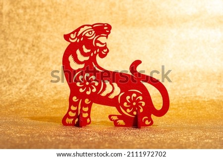 Chinese New Year of tiger 2022 mascot paper cut on a gold background