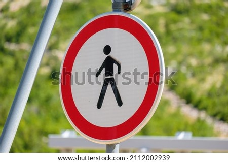 Traffic sign prohibited entry for people depicting a walking person inside a red circle. 