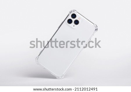 Silver iPhone 11 and 12 Pro max in clear silicone case falls down back view, phone case mockup isolated on gray background Royalty-Free Stock Photo #2112012491