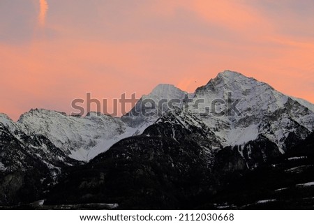 Orange and lilac vivid sunset over snow capped alpine mountains (Aosta, Italy)	Autumnal wallpaper or screensaver feel. Fall seasonal vibes and cozy feelings. Awe inspiring landscapes
