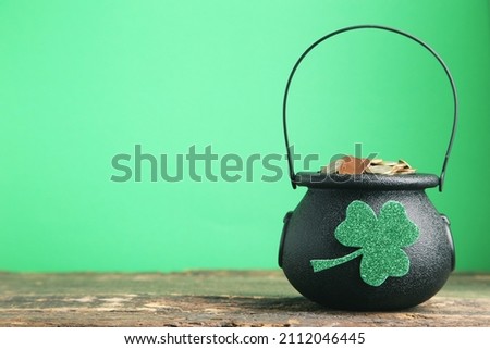Pot of coins and clover leaf on green background. Concept St.Patrick's Day