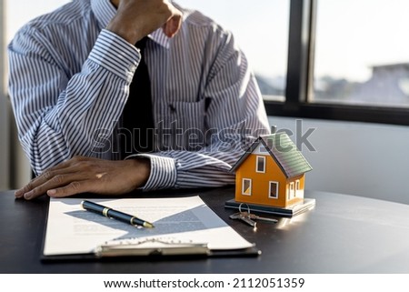 The salesperson of the housing estate in the project is preparing and verifying the contract of sale for the customer who will enter the contract. Concept of selling housing estates and real estate.