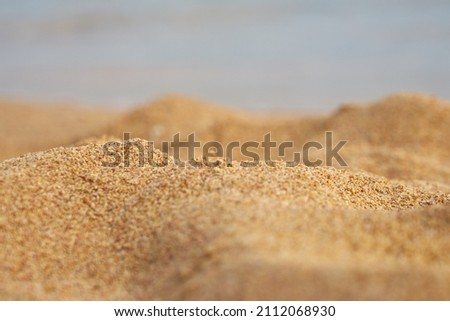 Sand closeup with blurred sea on the background