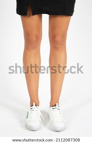 woman in stylish sneakers on white background