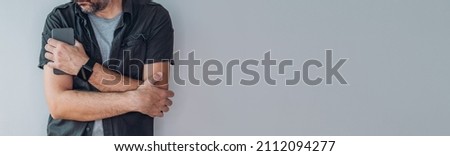 Casual man using smart mobile phone for communication, panoramic image with selective focus
