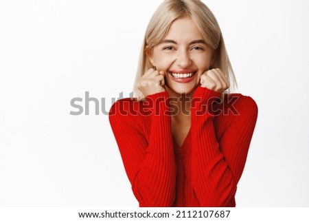 Close up portrait of beautiful and stylish woman with lipstick, red crop top, laughing and smiling, blushing on valentines lovers day, standing over white background
