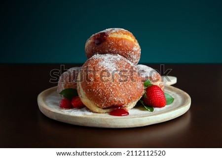 Fresh baked strawberry fruit jam filled donuts with a sugar glaze.  Royalty-Free Stock Photo #2112112520