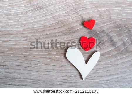 Three hearts on a wooden background. Concept for valentine's day, mother's day or parental care concept for a child. With copy space