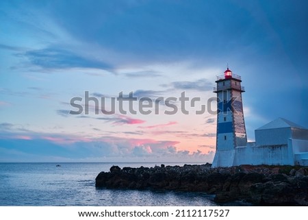 Farol Museu de Santa Marta. Lighthouse and Museum in Cascais, Portugal. Beautiful sunset on the sea shore. Royalty-Free Stock Photo #2112117527