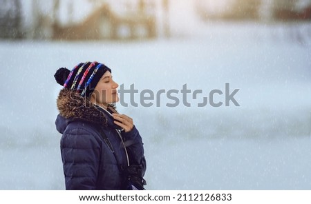 Portrait of a Nice Female Enjoying Snowfall. Having Fun in Cold Winter Weather. Happy Life.