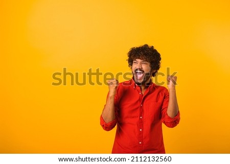 Extremely excited overjoyed man with beard shouting making yes gesture, amazed with his victory, triumph. Indoor studio shot isolated on yellow background Royalty-Free Stock Photo #2112132560