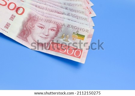 Swedish krona on a blue background with a large denomination. High quality photo Royalty-Free Stock Photo #2112150275