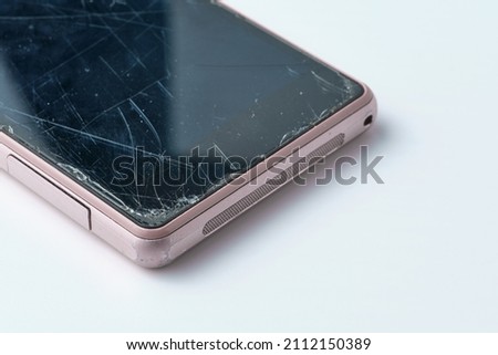 worn pink smartphone with cracked and scratched screen on white background Royalty-Free Stock Photo #2112150389