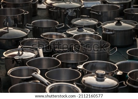 Selective blur on second hand kitchenware: metalware like pots and saucepans, pans, caldrons, in stainless steel and aluminum in the flea market of Obrenovacki Vasar. 

 Royalty-Free Stock Photo #2112160577