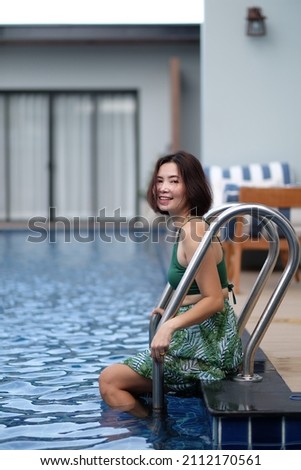 Beautiful girl happy in the swimming pool relax and play by the pool Summer vacation.