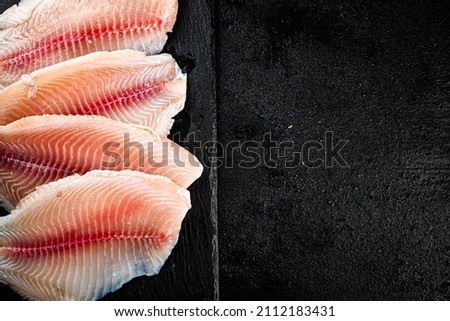 Raw fish fillet on a stone board. On a black background. High quality photo