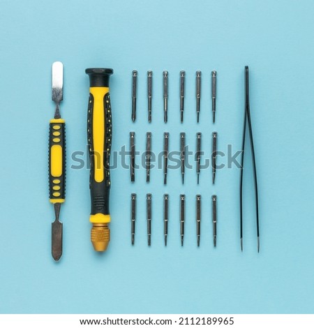 A set of tools made of screwdrivers and tweezers on a blue background. Accessories for repair.