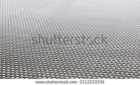 Black plastic woven background. The texture of the weave rubber material found in modern outdoor furniture. Abstract background concept. Selective focus
