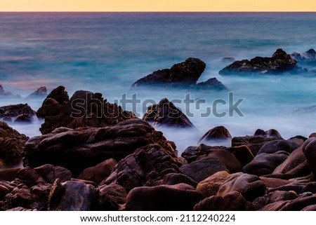 waves of the sea between the big stones in the coast long shot exposure picture of puerto escondido oaxaca 