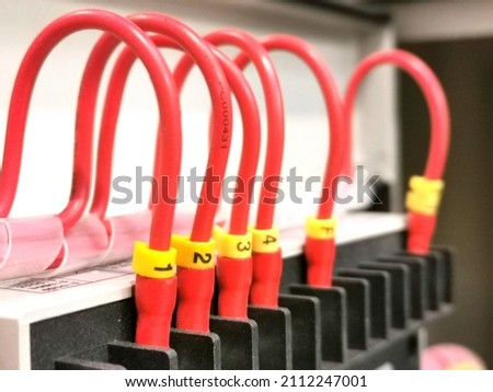 A row of red pvc cables connection with markers.