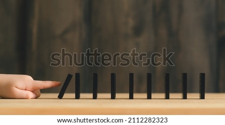 Child's hand started domino effect. Concept and idea. Shallow depth of field.
 Royalty-Free Stock Photo #2112282323