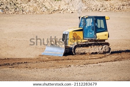 Crawler dozer with blade for leveling ground. Road construction, earthmoving on construction site. Bulldozer works. Track-Type tractor for land clearing and heavy dozing. 
 Royalty-Free Stock Photo #2112283679
