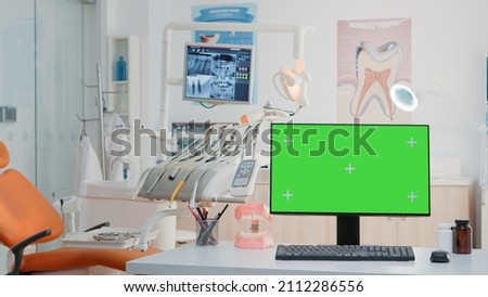 Empty dental cabinet with horizontal green screen on monitor. Nobody in dentist office for dentistry care with isolated background and mockup template on computer. Stomatological tools